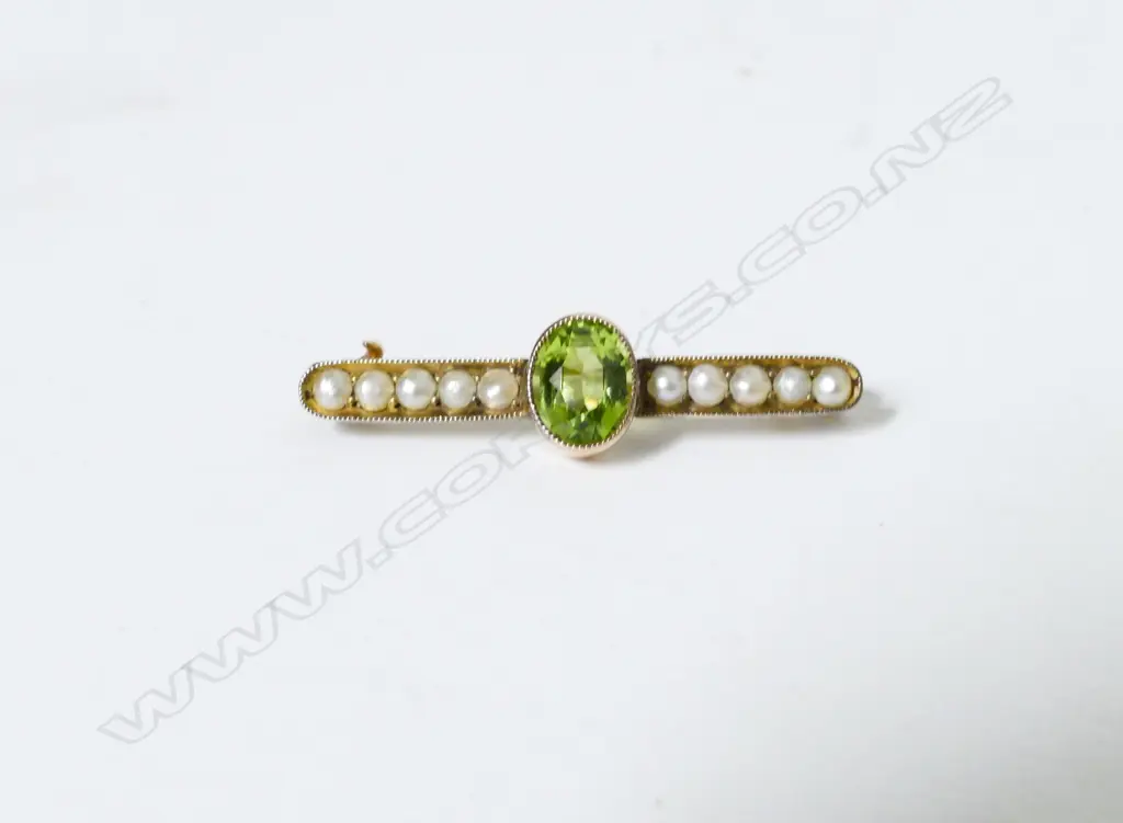 An antique 9ct. gold peridot and pearl bar brooch Image 1++