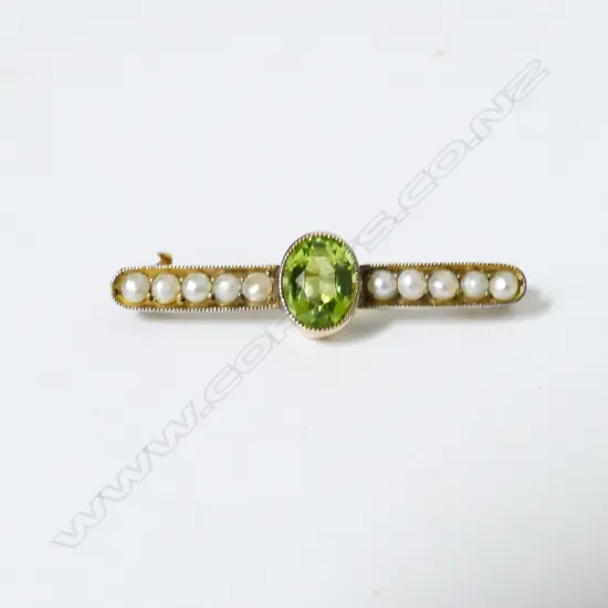 An antique 9ct. gold peridot and pearl bar brooch