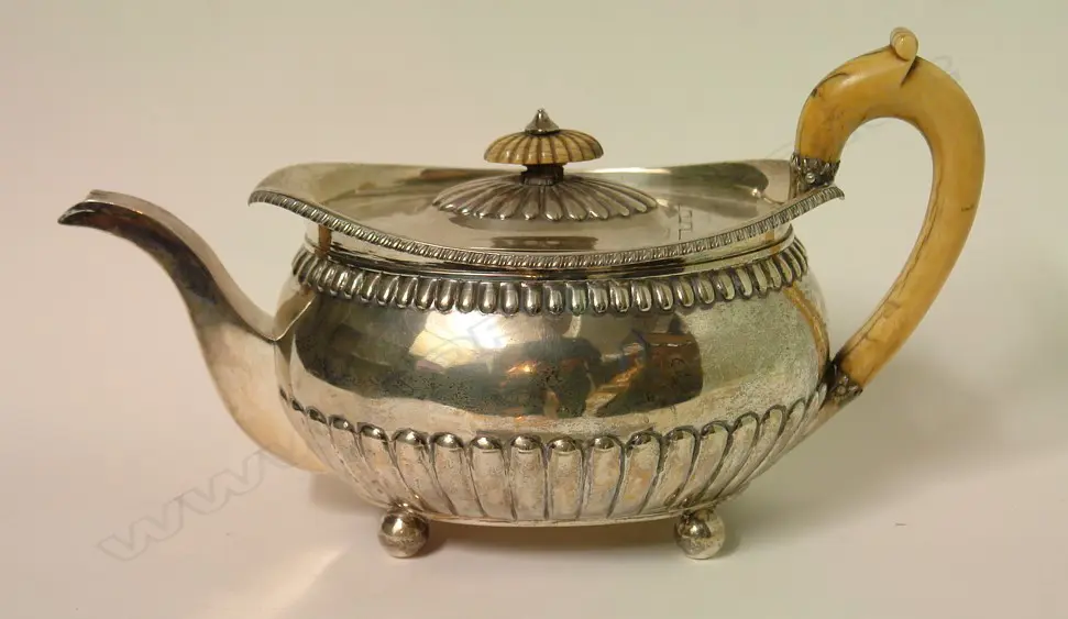 A George III silver oval teapot on four ball feet Image 1++