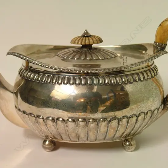 A George III silver oval teapot on four ball feet