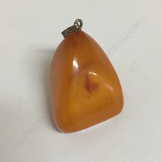 An amber large polished nugget pendant drop