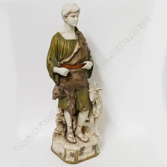 A large Royal Dux bone china figure of a young man accompanied by a goat