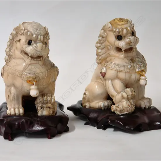 A pair of old carved ivory Chinese temple lion dogs