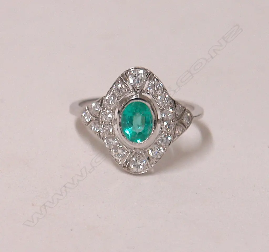 An 18ct. white gold Art Deco style emerald and diamond cluster ring Image 1++