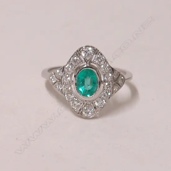 An 18ct. white gold Art Deco style emerald and diamond cluster ring