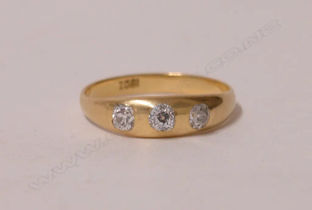 An 18ct. yellow gold estate three-stone diamond gypsy set ring Image 1++