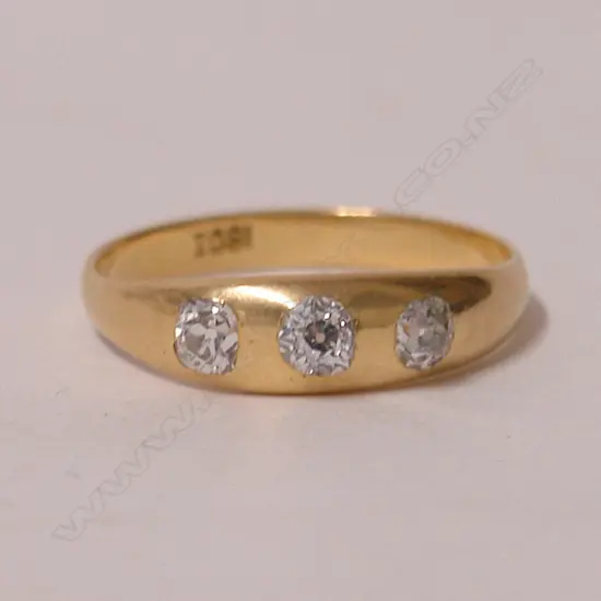An 18ct. yellow gold estate three-stone diamond gypsy set ring