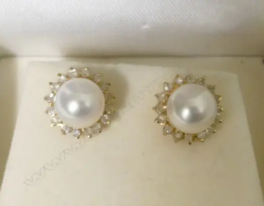 A pair of 9ct. gold pearl and diamond stud earrings Image 1++