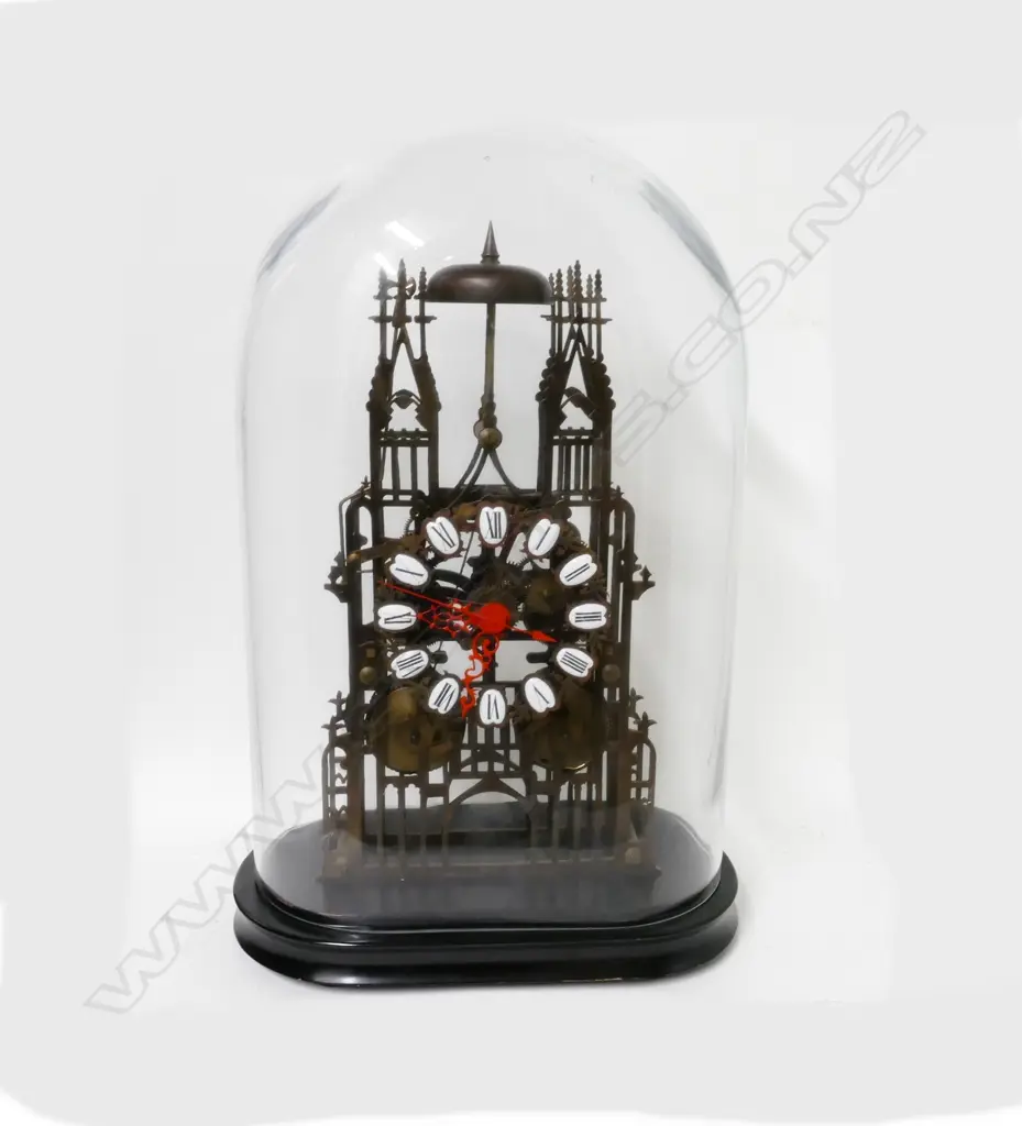 A brass skeleton clock under glass dome Image 1++