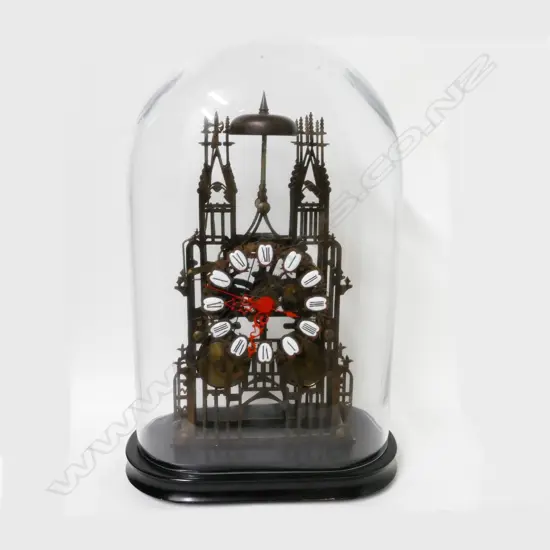 A brass skeleton clock under glass dome