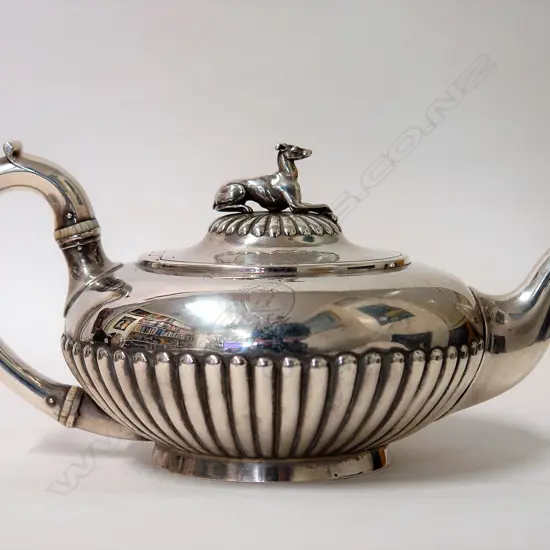 A heavy Victorian silver teapot with greyhound finial