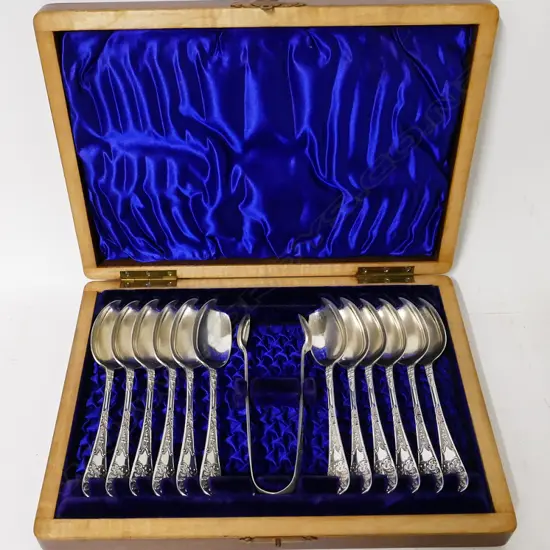 A walnut cased set of 12 silver teaspoons and a pair of sugar tongs