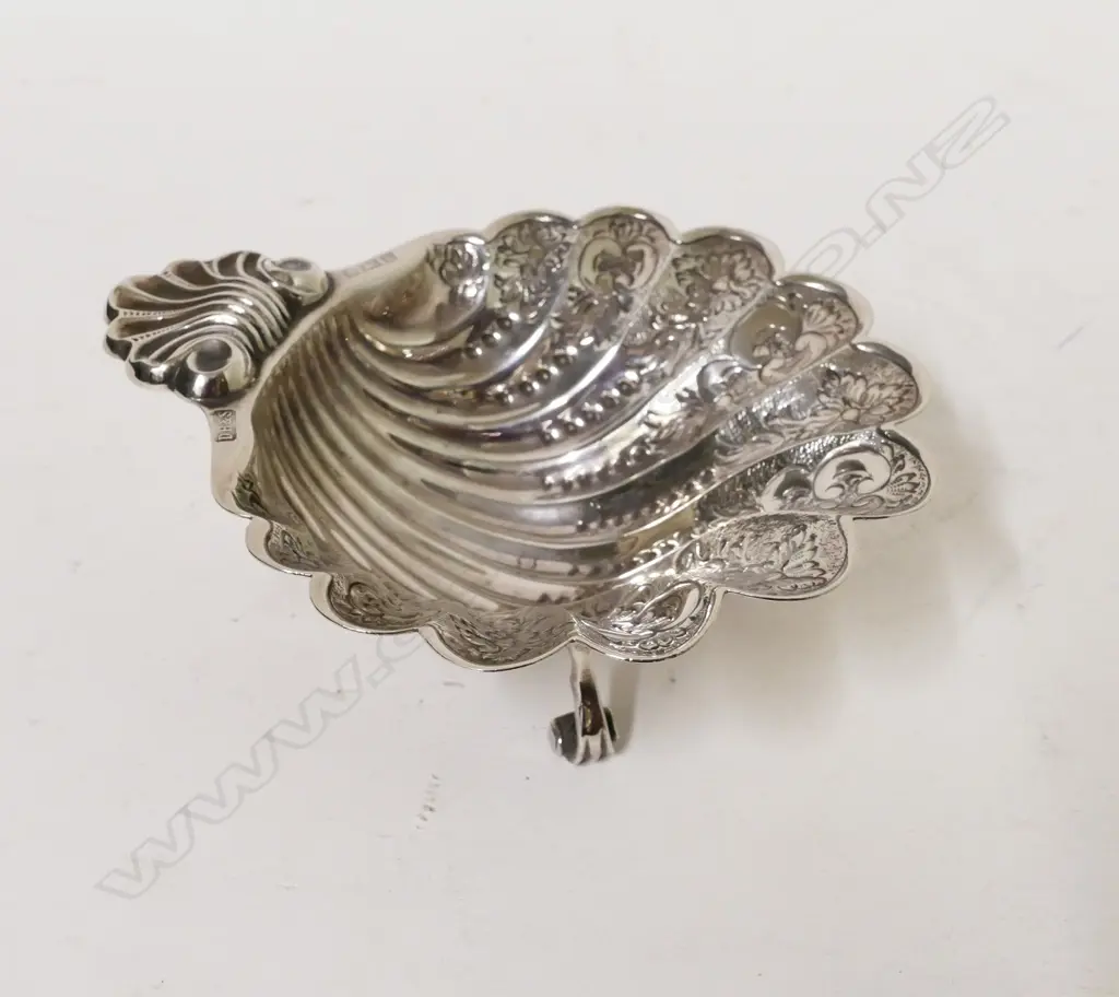 A silver scalloped shaped dish Image 1++