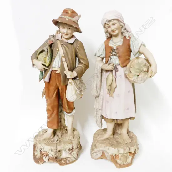 A pair of Royal Dux figures of a young huntsman and his fisherwoman companion