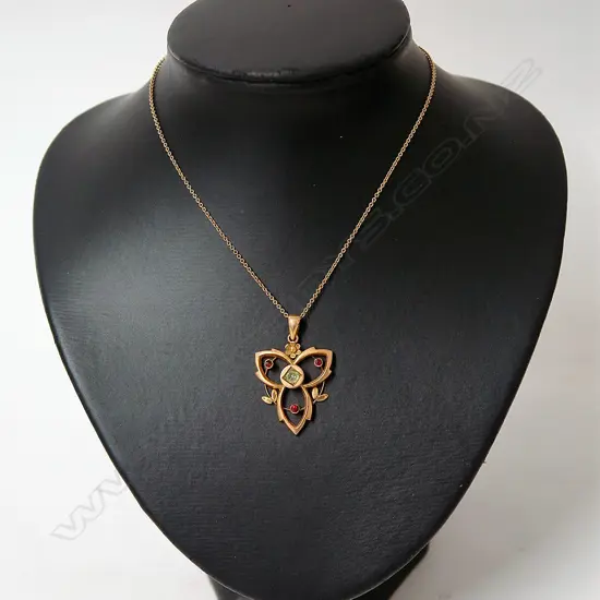 An Edwardian 9ct. yellow gold peridot and garnet pendant