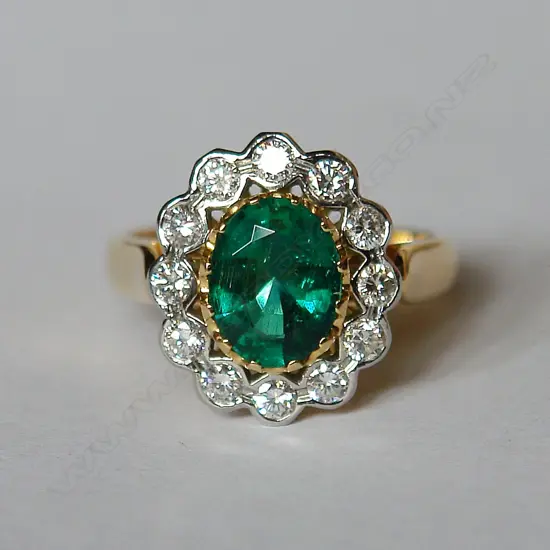 A lady's modern emerald and diamond cluster ring