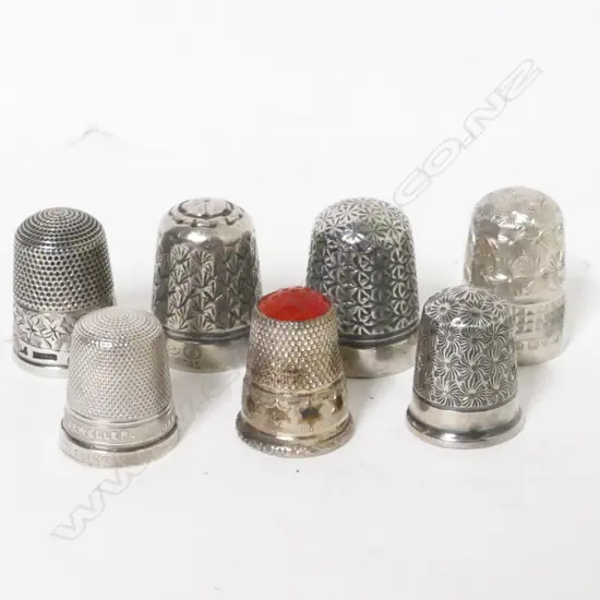 A collection of five silver thimbles and two plated thimbles