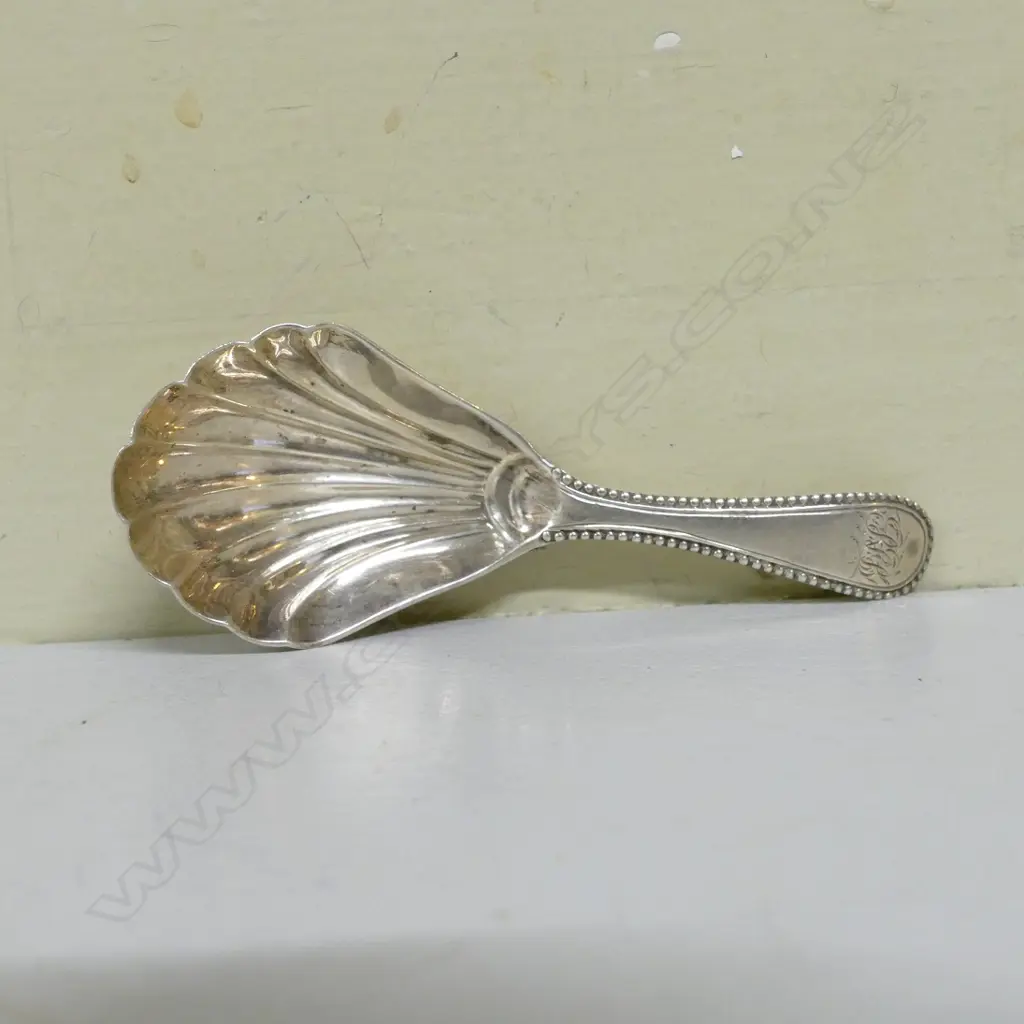 A George IV silver caddy spoon with shell bowl and a broad engraved handle Image 1++