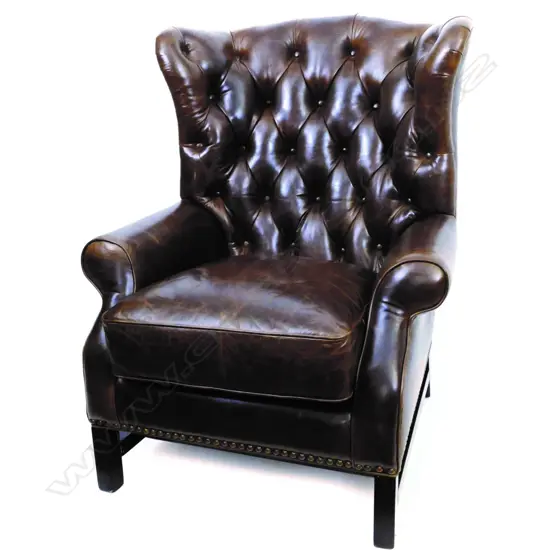A good modern dark brown buttoned leather wingback armchair