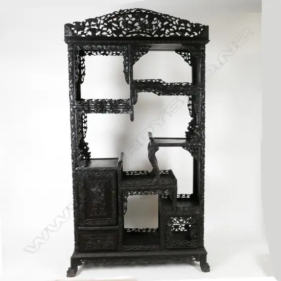 An ornate Chinese blackwood carved display cabinet