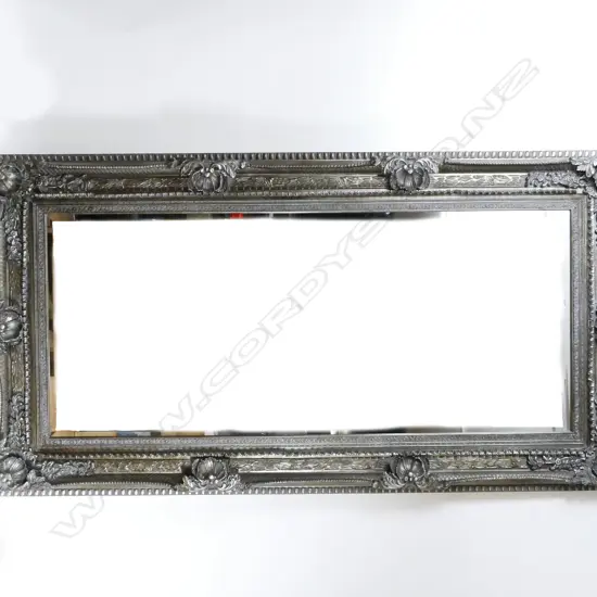 A large and ornate moulded framed overmantel mirror